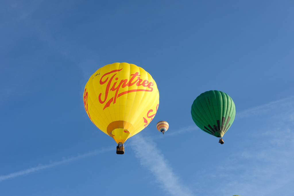 three hot air balloons in a blue sky