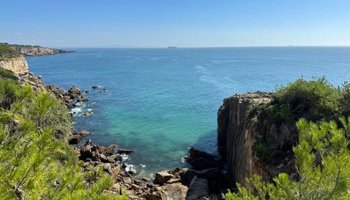 Rocky cliffs around the ended, with the atlantic ocean off into the horizon. The sky is clear.