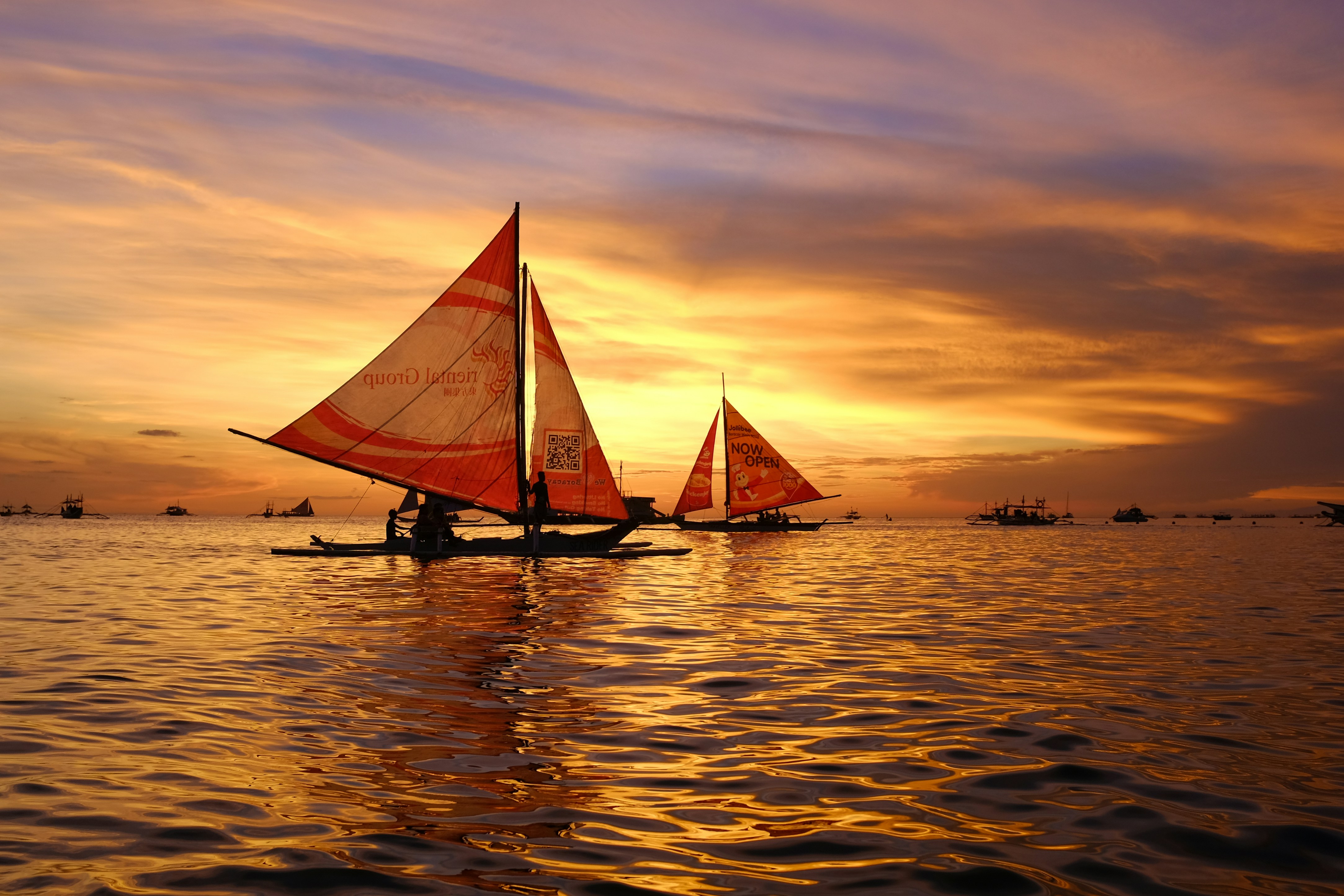 sailboats in the ocean at twilight