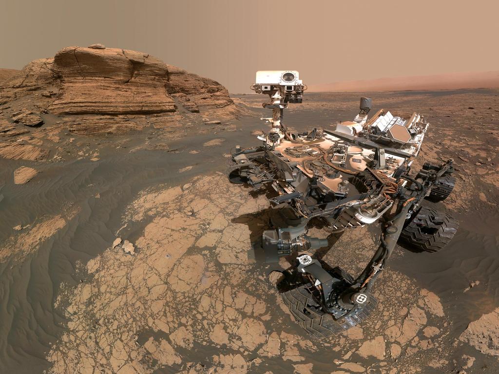 A stunning selfie of the Curiosity rover with 'Mont Mercou' in the background, showcasing the Martian terrain.