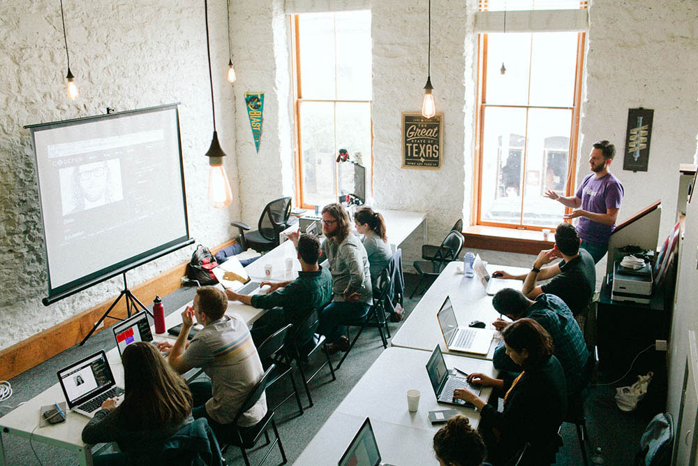 Overhead photo of many students on computers doing an HTML and CSS workshop